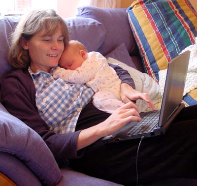 True multi-tasking - Mandy checks her email while Misha sleeps on her chest.